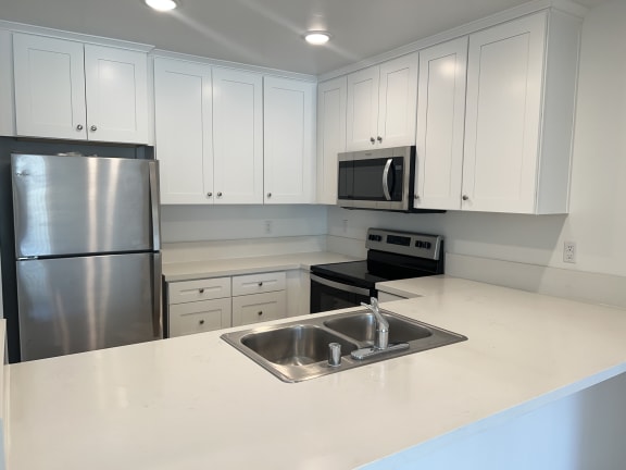 Floor Plan  a kitchen with white cabinets and a sink and a refrigerator